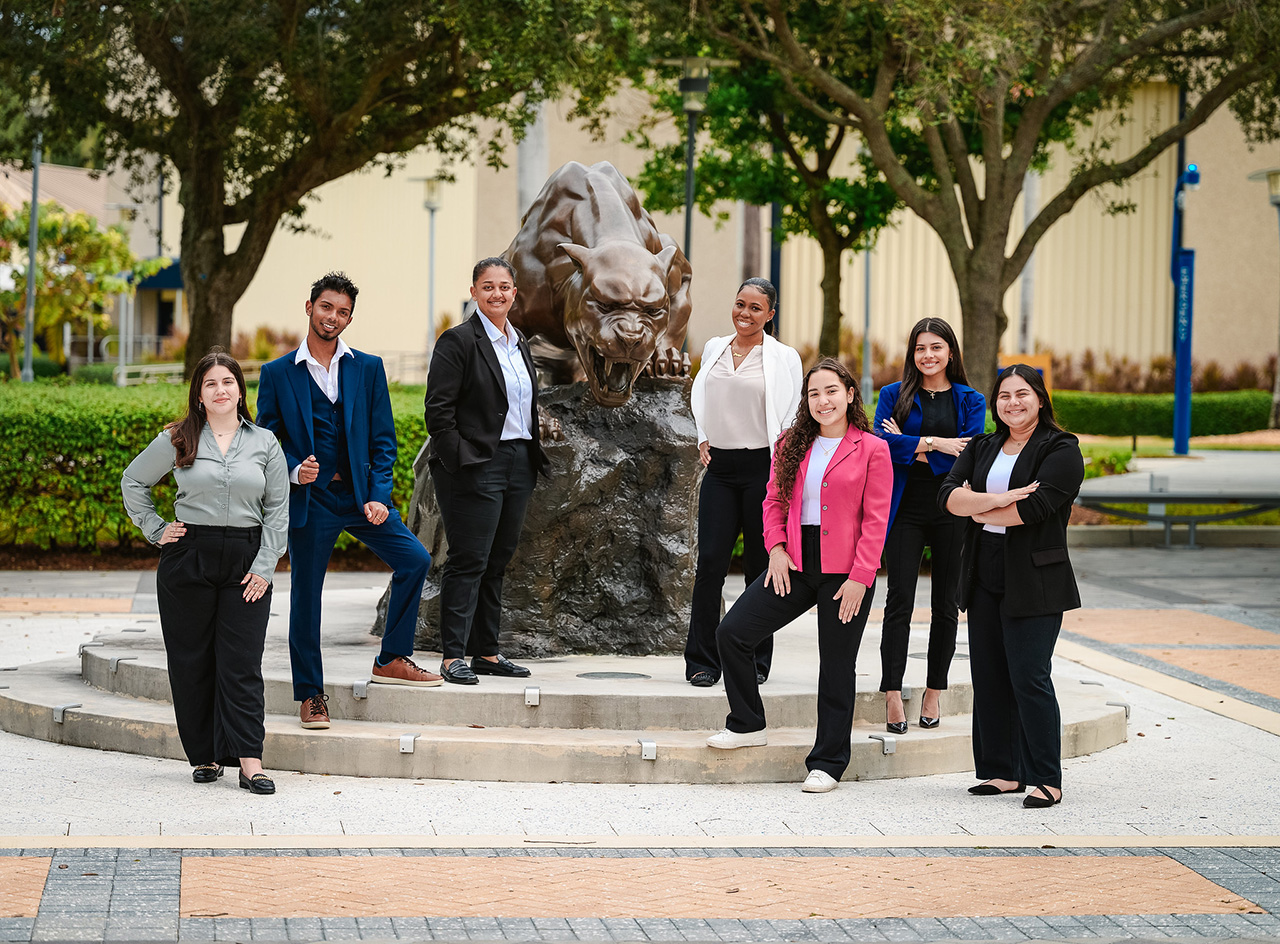 FIU Hospitality Students Posed around an FIU Panther Mascot Statue